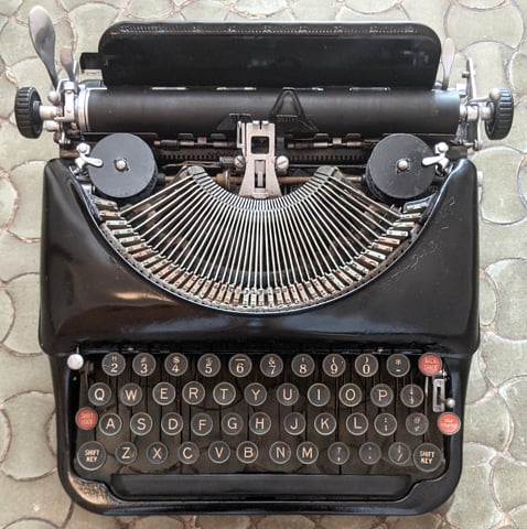 1930s Remington portable typewriter with QWERTY layout. Photo by Mariochs, distributed under a CC BY-SA 4.0 International license.