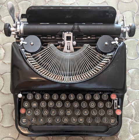 The connecting levers are visible between the keys of this 1930s Remington portable typewriter. Photo by Mariochs, distributed under a CC BY-SA 4.0 International license.